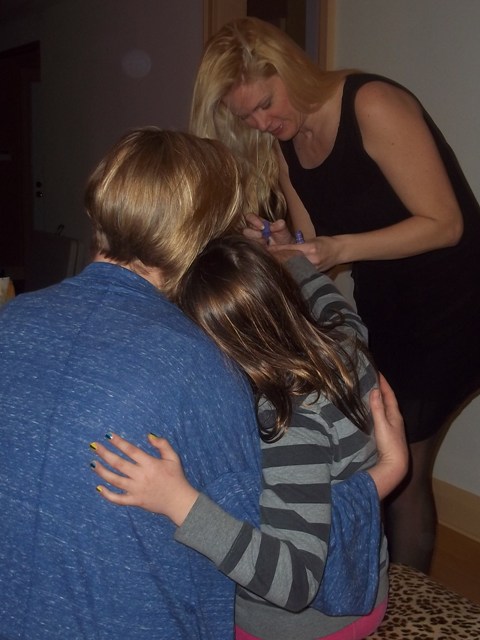 photo of melanie painting little girl's nails and mother holding the daughter