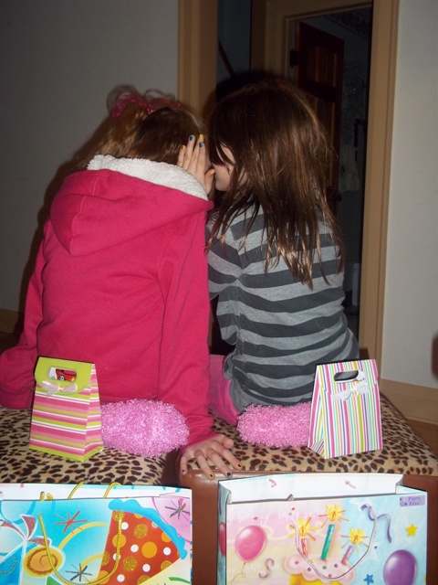 one girl whispering in another girls ear at a mother and daughter themed party in toronto